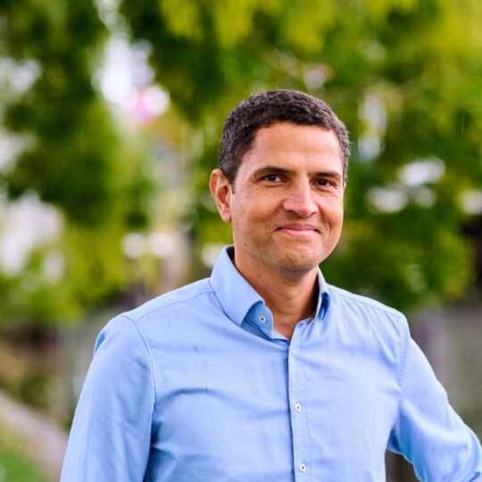 Collega, adviseur Asset, poseert voor een een groenrijk gebied in Amsterdam