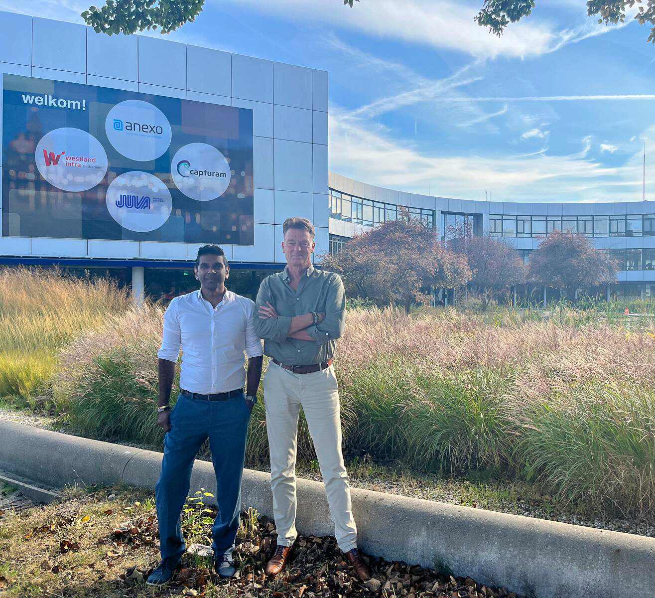 Sander en Rickie staan voor een groot gebouw te poseren -2