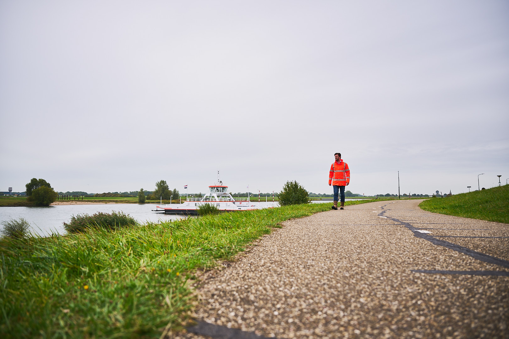 Collega loopt over Sterke Lekdijk met veiligheidsjas.